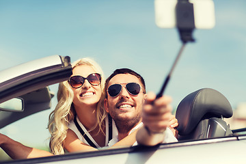 Image showing happy couple in car taking selfie with smartphone