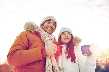 Image showing happy couple with tea cups over winter landscape