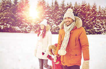 Image showing happy family in winter clothes walking outdoors