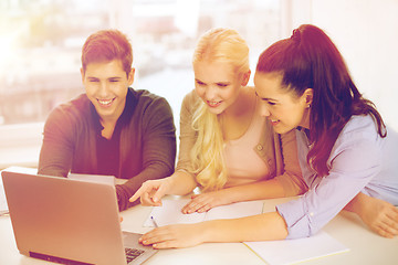 Image showing three smiling students with laptop and notebooks