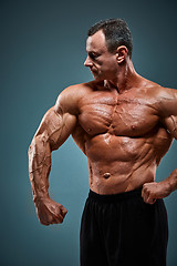 Image showing torso of attractive male body builder on gray background.