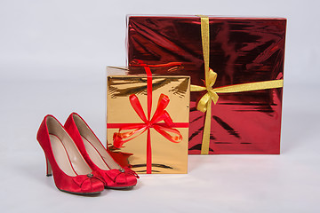 Image showing Red female shoes with high heels, standing next to two boxes with gifts