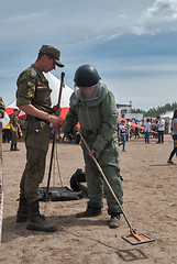 Image showing Man - visitor of show tries on the sapper suit