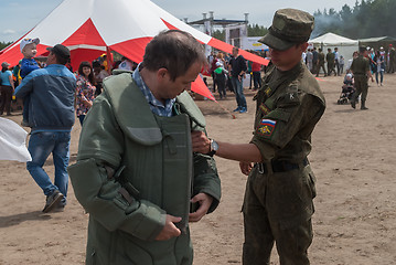 Image showing Man - visitor of show tries on the sapper suit