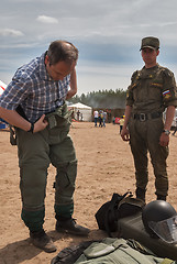 Image showing Man - visitor of show tries on the sapper suit