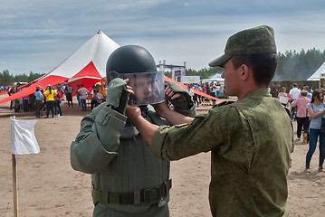 Image showing Man - visitor of show tries on the sapper suit