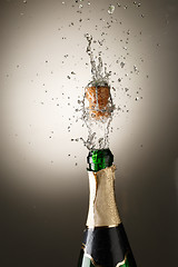 Image showing Champagne bottle with cork popping and splash