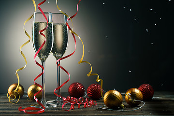 Image showing Two glasses with sparkling champagne, snowflakes and Christmas balls