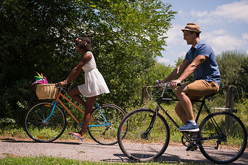 Image showing Young multiethnic couple having a bike ride in nature