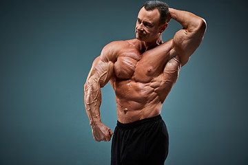 Image showing torso of attractive male body builder on gray background.