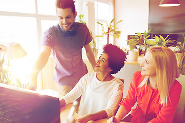 Image showing happy creative team with computer in office