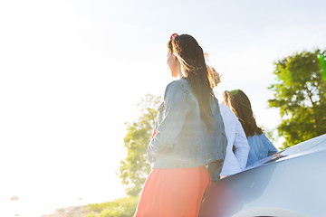 Image showing happy teenage girls or women near car at seaside