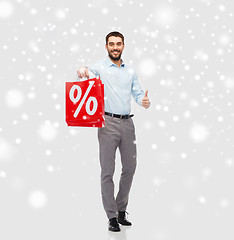 Image showing happy man with red shopping bag showing thumbs up