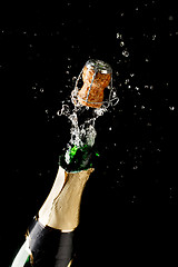 Image showing Bottle of champagne exploding isolated on black background