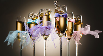 Image showing Glasses with champagne dressed in tie bows and veil