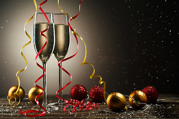 Image showing Two glasses with champagne and Christmas decoration. Holiday concept