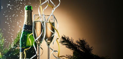 Image showing Champagne bottle and glasses on background of Christmas tree branches