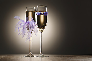 Image showing Two glasses of champagne decorated bride and groom clothing