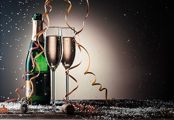 Image showing Bottle of champagne and filled glasses decorated in festive theme