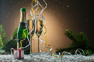 Image showing Two glasses of white champagne, open bottle and Christmas decorations