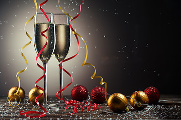 Image showing Two champagne glasses decorated ribbons and toys. on black background