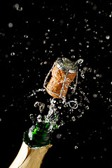 Image showing Opening bottle of champagne on empty black background