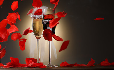 Image showing Elegant champagne glasses for bride and groom with rose petals