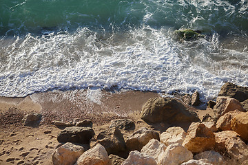 Image showing Large stones on sandy beach and waves washing it