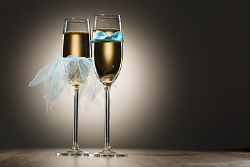 Image showing Champagne glasses dressed in blue grooms bowtie and brides veil