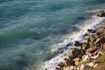 Image showing Wild beach with rocky shore and pure black sea