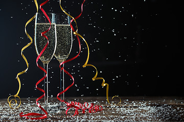 Image showing Two glasses of fizzy champagne with beautiful ribbons and snow