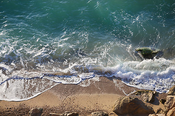 Image showing Coastal landscape with sea waves and large boulders on beach