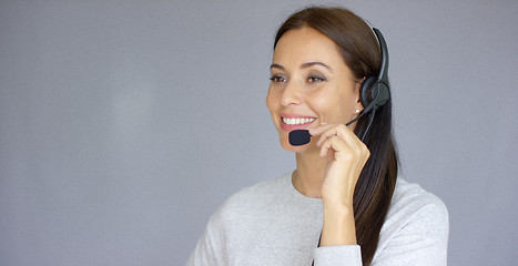 Image showing Beautiful and positive female call center agent at work