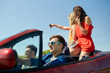 Image showing friends driving in cabriolet car and taking selfie