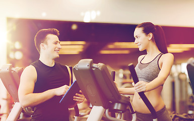 Image showing woman with trainer exercising on stepper in gym