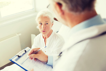 Image showing senior woman and doctor with clipboard at hospital