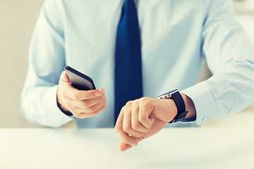 Image showing close up of hands with smart phone and watch