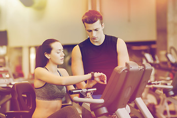 Image showing woman with trainer on exercise bike in gym