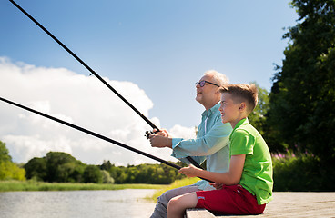 Image showing grandfather and grandson fishing on river berth