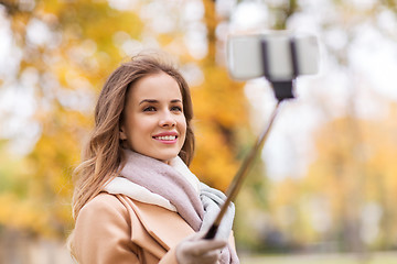 Image showing woman taking selfie by smartphone in autumn park