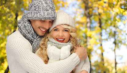 Image showing happy couple in warm clothes over autumn