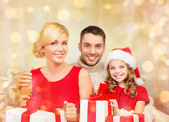 Image showing smiling family holding many gift boxes