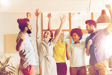 Image showing happy creative team celebrating victory in office