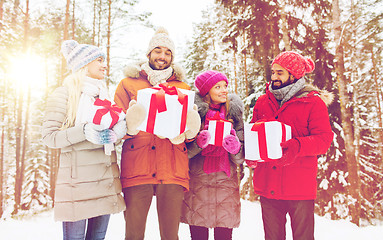 Image showing happy friends and christmas gifts in winter forest