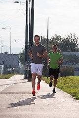 Image showing Two young men jogging through the city