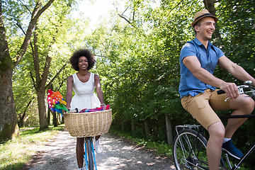 Image showing Young multiethnic couple having a bike ride in nature