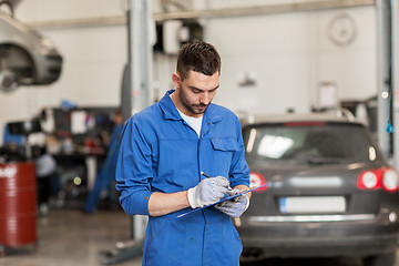 Image showing auto mechanic man with clipboard at car workshop