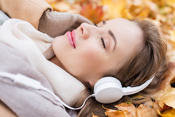 Image showing woman with headphones listening to music in autumn