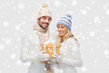 Image showing smiling couple in winter clothes with gift box