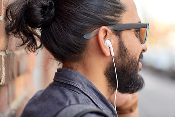 Image showing close up of man with earphones listening to music